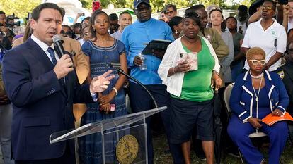 Florida Gov. Ron DeSantis, left, speaks at a prayer vigil for the victims of a mass shooting a day earlier, in Jacksonville, Florida, on Aug. 27, 2023.