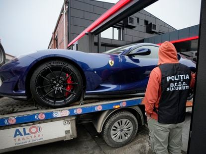 A police officer looks on as a luxury vehicle which was seized in a case against media influencer Andrew Tate, is towed away, on the outskirts of Bucharest, Romania, Saturday, Jan. 14 2023.