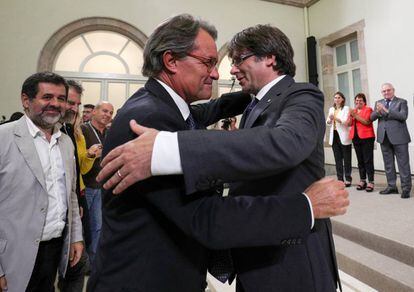 Catalan regional premier Carles Puigdemont (R) embraces his predecessor Artur Mas after the regional parliament voted to hold a referendum on independence from Spain.