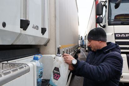 A Ukrainian driver adds antifreeze to his vehicle on November 26 in Medyka.