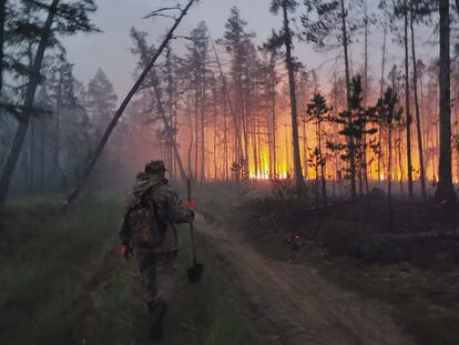 A volunteer walks towards a fire in Yakutia, in the Siberian Arctic, on July 17, 2021.