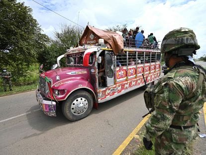Indigenous Colombians on a bus are observed by members of the military outside Cali on Wednesday.