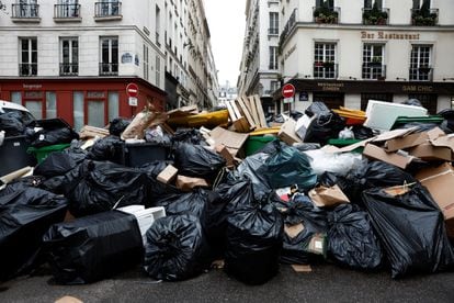 A view of a street where garbage cans are overflowing, as garbage has not been collected, in Paris, France March 13, 2023. 