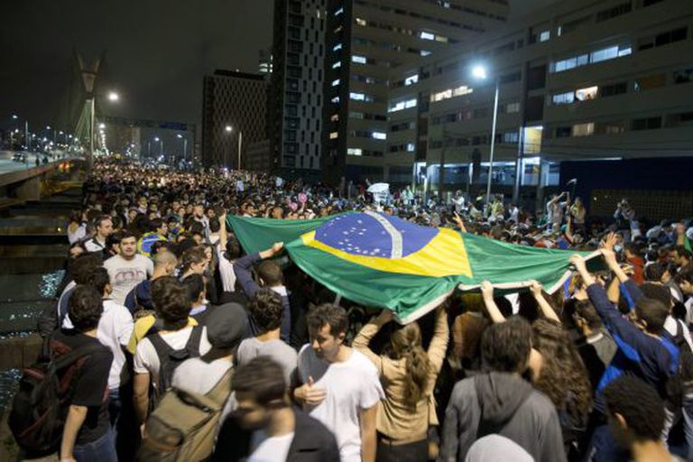 Students lift a Brazilian flag during Monday night's protest in São Paulo.