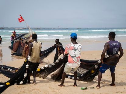 Three young fishermen from Kayar, a coastal city in the Thiès region, pull the nets of a fishing canoe. The artisanal fishing crisis, caused by the activity of large foreign vessels, is impacting migration. Many of those who arrive in the Canary Islands on canoes are fishermen from Mbour, Kayar or Saint Louis.