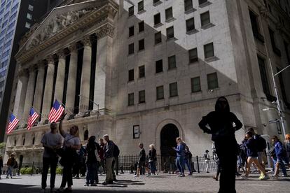 Visitors to the financial district walk past the New York Stock Exchange, Friday, Sept. 23, 2022, in New York.