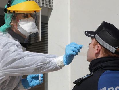 A medical biologist handles a swab to test a police officer at Casa de Campo in Madrid in March.