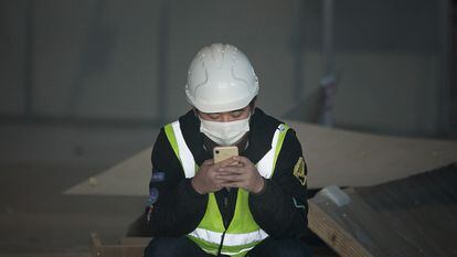 A worker looks at his cellphone in Barcelona, last February.