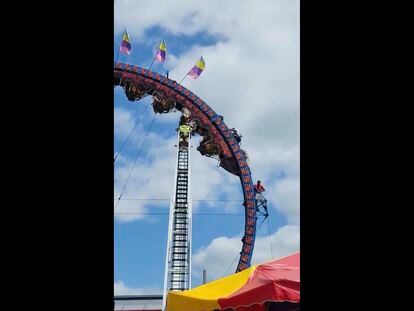 In this image made from video provided by TMX, eight people are trapped upside down on a roller coaster — some of them for more than three hours — at a festival in Wisconsin.