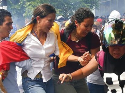 María Corina Machado flees the tear gas fired at Tuesday's rally.