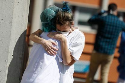 Two health workers hug outside the Severo Ochoa hospital in Leganés.