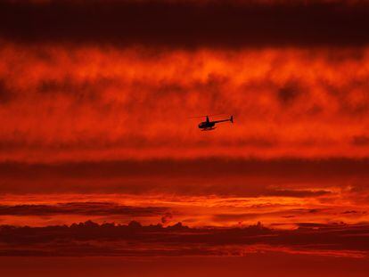 A helicopter travels south along the coast after sunset over the ocean as Hurricane Hilary approaches Del Mar, California, U.S., August 19, 2023.