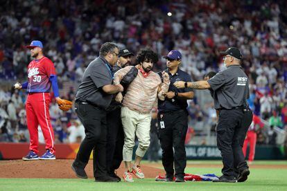 A fan is removed from the field after running on during the World Baseball Classic Semifinals between Team Cuba and Team USA