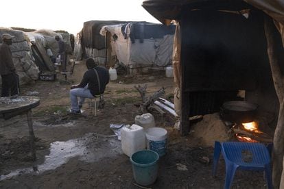 A man sits outside a shack in the makeshift camp.