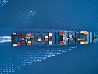 Large container ship is approching the port full loaded with containers and cargo - aerial - top down view. Shanghai, Shanghai, China