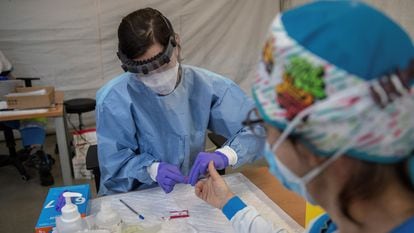 A health worker performs a fast test on a member of Madrid’s emergency health services.