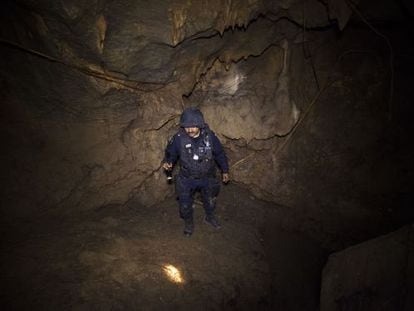 A policeman searches the cave where La Tuta hid out.