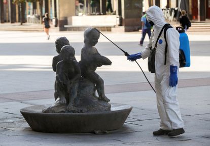 A cleaner disinfects a statue at Pilar square in Zaragoza.
