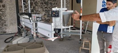 empleado de Wasp explica el funcionamiento de su impresora de cemento para construcciones