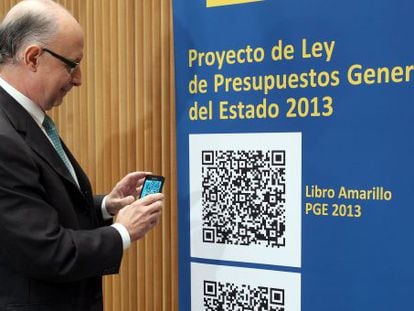 Finance Minister Crist&oacute;bal Montoro poses with a QR-Code version of the 2013 draft state budget.