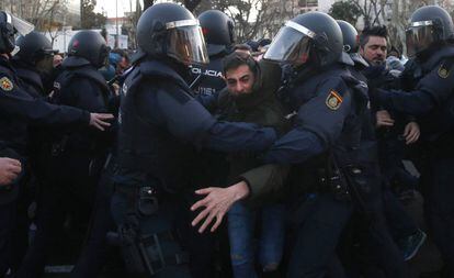 Police offers try to remove a taxi driver who parked his car on Paseo de la Castellana, a major thoroughfare in Madrid.