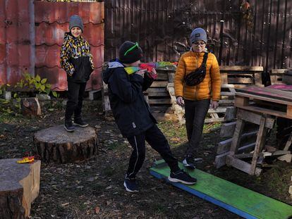 In Irpin, on Tuesday, November 1, a group of children play beside pallets that their parents will chop up to be used as firewood for the winter.