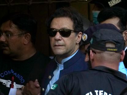 Pakistan's former Prime Minister Imran Khan, center, is escorted by security officials as he arrive to appear in a court, in Islamabad, Pakistan, Friday, May 12, 2023.