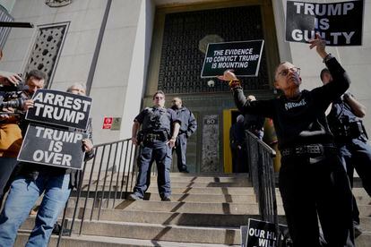Protesters hold signs on the steps in front of the New York City administration building