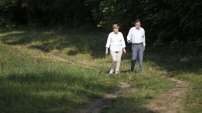 Angel Merkel and Mariano Rajoy take a walk in Meseberg, Germany last August.