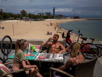 Local customers sit in a restaurant next to a beach in Barcelona.