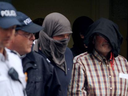ETA member Juan Maria Mugica Dorronsoro (R), is escorted by policemen as he leaves the court following a hearing on Thursday in Pau, southwestern France.