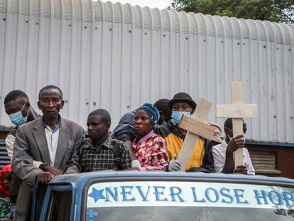 Relatives ride in the back of a truck with the coffins of villagers who were killed by suspected rebels as they retreated from Saturday's attack on the Lhubiriha Secondary School, outside the mortuary of the hospital in Bwera, Uganda Sunday, June 18, 2023.