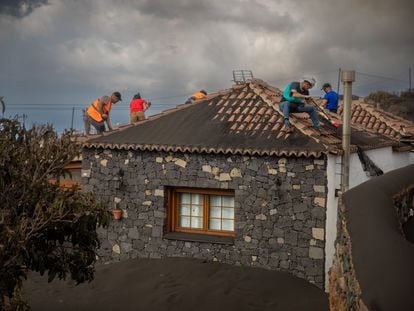 Volunteers clear away ash from a home in La Palma.