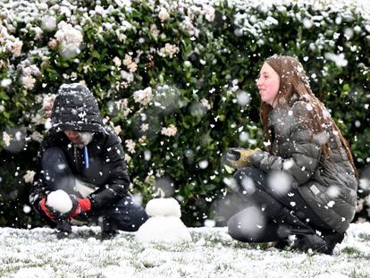 Brody Mielke, left, 10, and his older sister Braelynn, 12, make a snowman as snow falls at approximately the 1,700 foot level in front of their Fontana, Calif., home in Hunters Ridge on Saturday, Feb. 25, 2023.