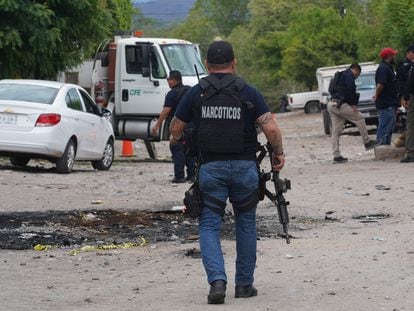 A Mexican narcotics agent investigates the scene of an armed attack in Michoacan; June 30.