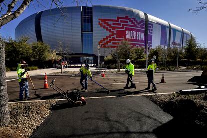 Workers prepare for the NFL Super Bowl LVII football game outside State Farm Stadium, Thursday, Feb. 2, 2023, in Glendale, Ariz.