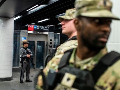 Police and National Guard soldiers patrol a New York subway station, March 7, 2024.
