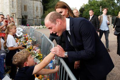 William, Prince of Wales, greets a child at the gates of Windsor Castle. 