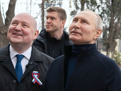 This handout photograph taken and released by the Russian presidential press office in Sevastopol on March 18, 2023, shows Russian President Vladimir Putin (R), talking to Sevastopol Governor Mikhail Razvozhayev (L), as he visits the Chersonesos Taurica historical and archeological park on the 9th anniversary of the referendum on the state status of Crimea and Sevastopol and its reunification with Russia.