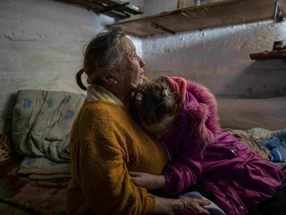 Khrystyna hugs her grandmother Liubov as they take cover at the basement of their house during the shelling in Bohoyavlenka, Ukraine, on Sunday, April 9, 2023.