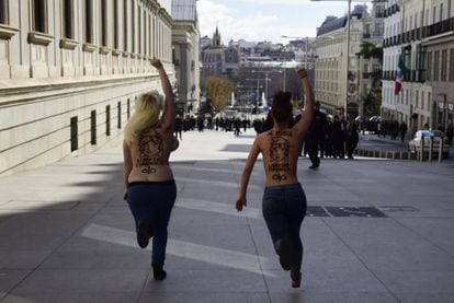 Bare-breasted activists from Femen run toward the Congress building on Tuesday.