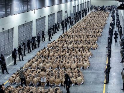 In this photo provided by El Salvador's presidential press office, inmates identified are seated on the floor of the Terrorism Confinement Center in Tecoluca, El Salvador, on March 15, 2023.