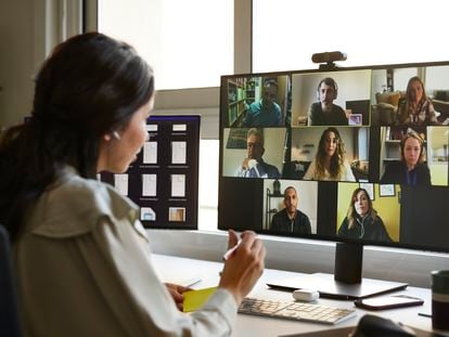 A woman talks to several people via video conference.