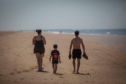 A family walks along Punta Umbría beach in Huelva province last Thursday.