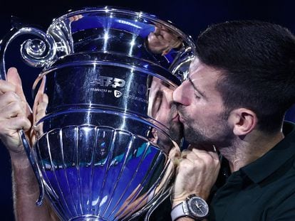 Novak Djokovic poses as he celebrates with the trophy for his 2023 world number one ranking