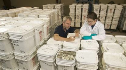 The cofounder of Odyssey Marine Exploration, Greg Stemm (l), examines coins recovered from the Mercedes. 
