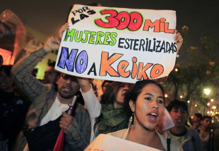 People hold a sign reading: "For the 300,000 sterilized women, no to Keiko" before the 2011 elections.