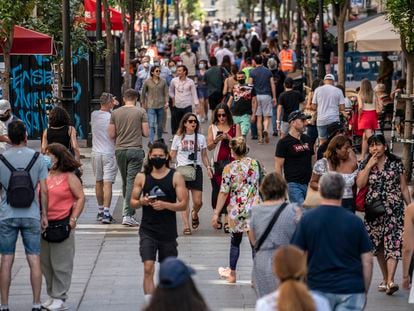 Dozens of people on a street in downtown Madrid in June 2021.
