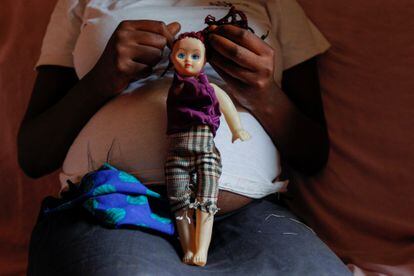 A young African woman, seven months pregnant, with a doll in Kenya, in September 2020.
