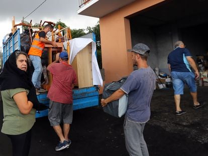 A family in La Laguna loads their possessions onto a truck on Tuesday.